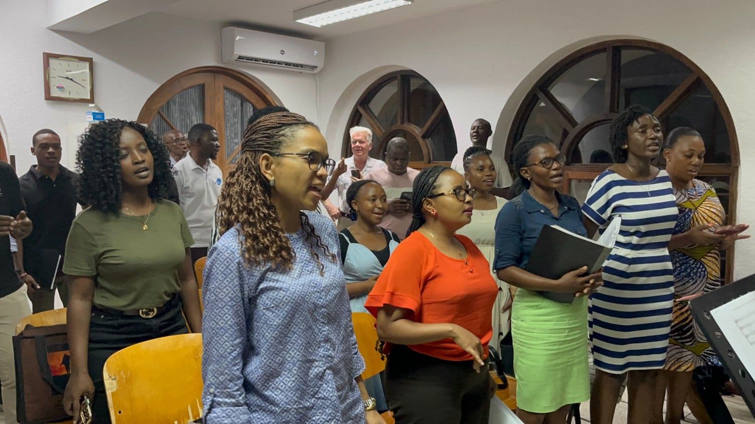 Choir rehearsing together with sheet music in hand