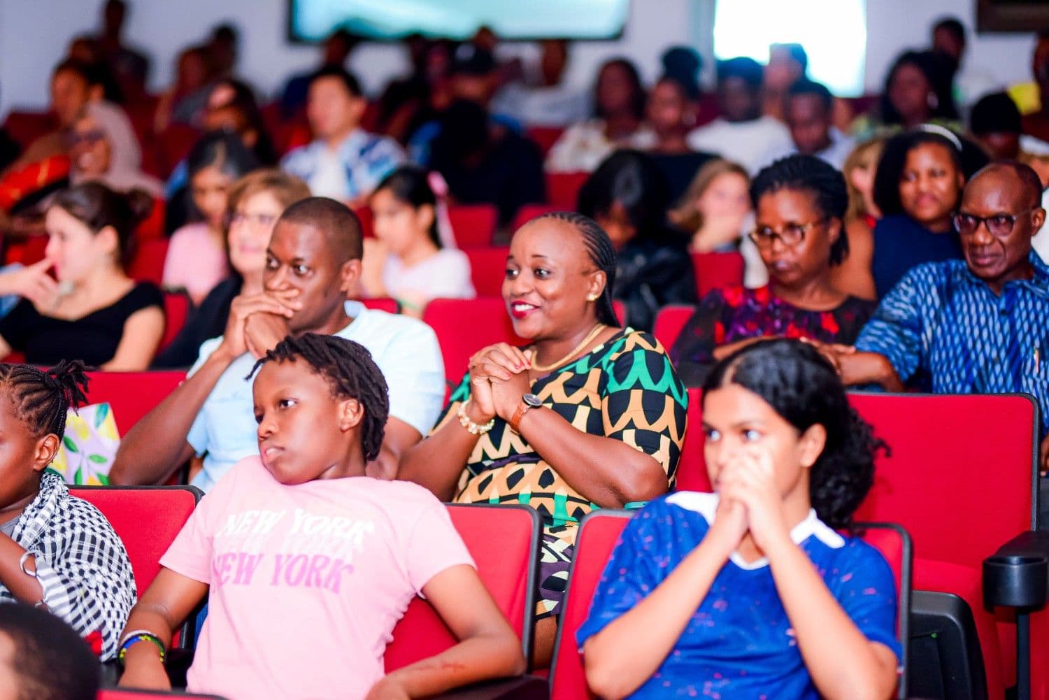 Audience in red theatre seats smiling during Timeless Echoes